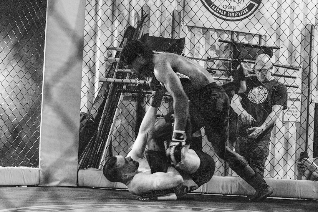Mixed martial arts fighters grappling in a cage.