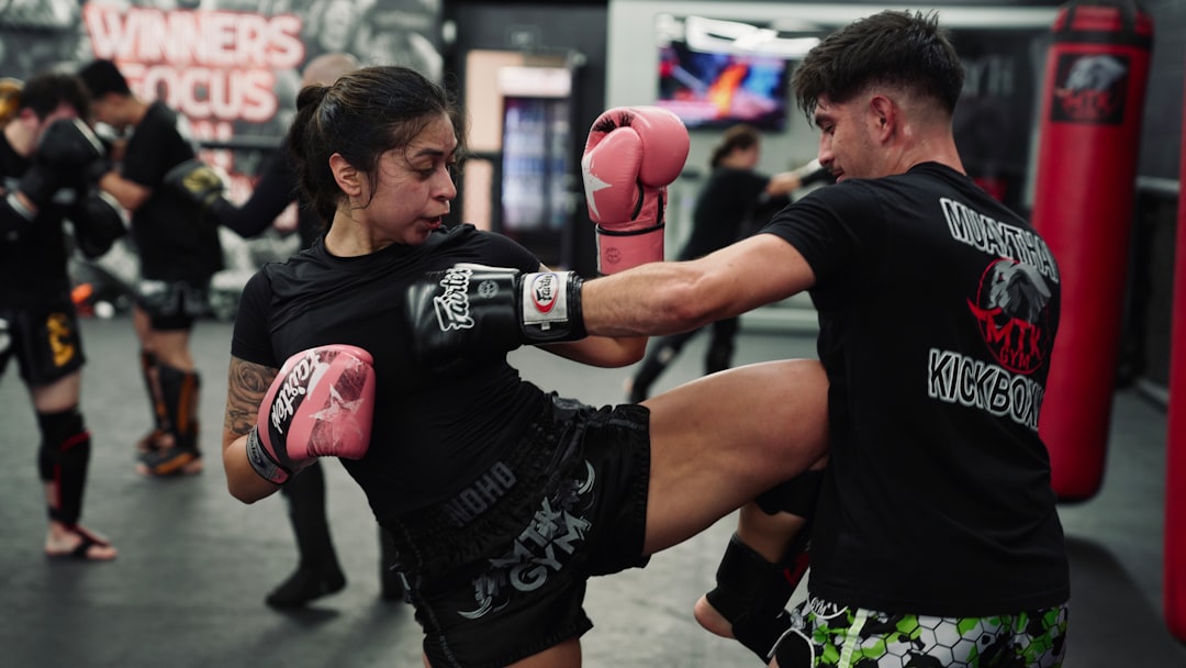 Woman and man training Muay Thai kickboxing