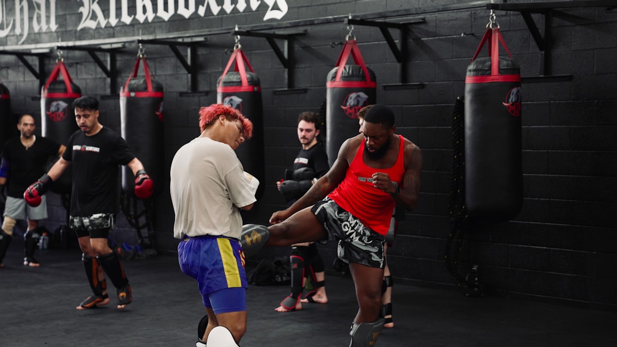 Men training kickboxing in a gym with punching bags