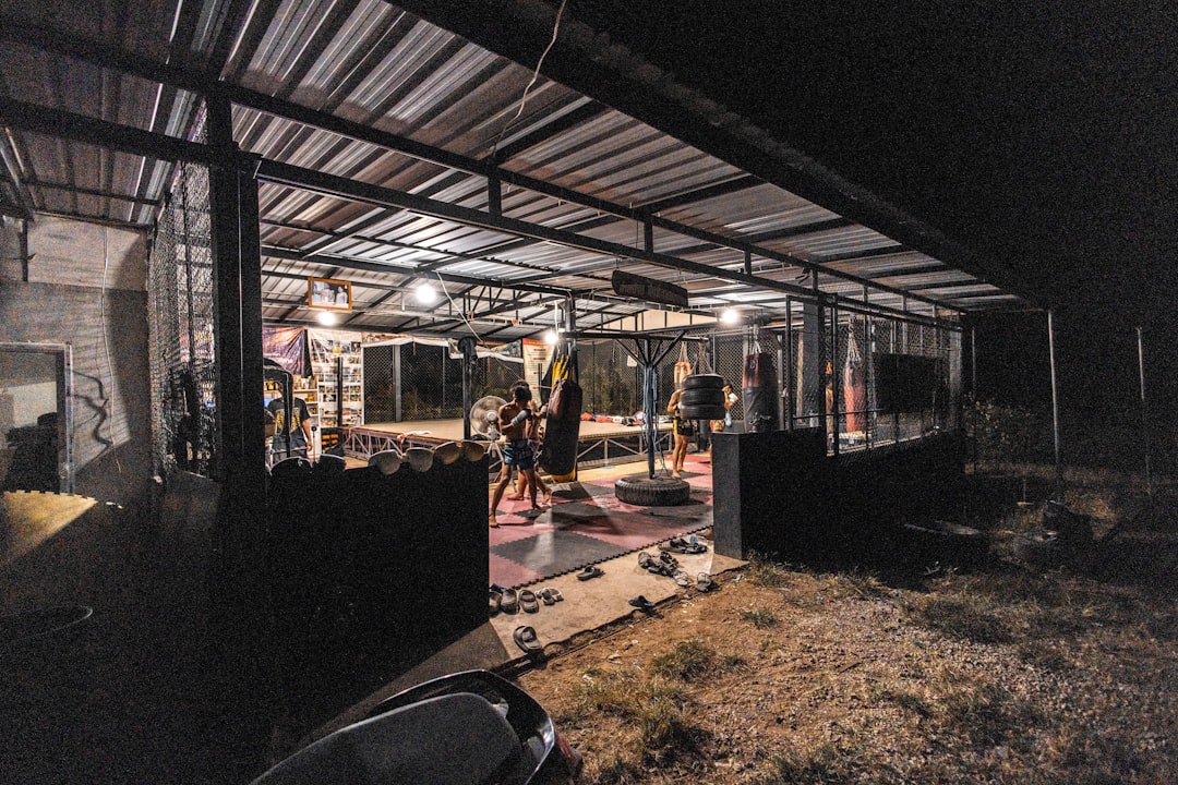 People exercising in a dimly lit outdoor gym at night